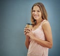 Mocha filled moments. Studio portrait of a young woman drinking a cup of coffee against a gray background. Royalty Free Stock Photo