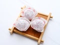 Mochi dessert served on bamboo board, isolated in white background.