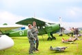 Mochishche airfield, local air show, biplane yak 12 M and two smiling young men in pilot clothes on vintage airplane background