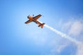 Mochishche airfield, local air show, yellow Extra EX 360 sports plane upside down on blue sky and white clouds background, closeup Royalty Free Stock Photo