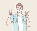 Happy young man with surgical medical mask with victory or confident hand sign gesture