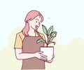 Young woman gardener taking care and squirts for house plant pots. Concept of home garden.