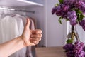 Mock-up, against the background of a closet with clean clothes, a hand shows like