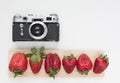 Mock up for artwork with old camera and red strawberries on white background. Top view. Place for text. Royalty Free Stock Photo
