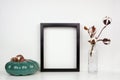 Mock up black frame with autumn pumpkin decor and cotton flowers on a shelf or desk