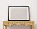 Mock up blank black picture frame on the white desk and wall, background Royalty Free Stock Photo