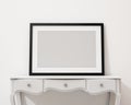 Mock up blank picture frame on the white desk and wall, background