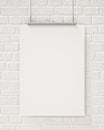 Mock up blank poster hanging on the white brick wall, background
