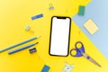 Mock up blank screen mobile phone for back to school or office background concept. Yellow and blue color Royalty Free Stock Photo