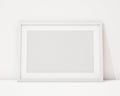 Mock up blank white horizontal picture frame on the white interior background
