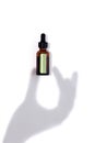 Mock up of brown glass serum or oil bottle with pipette and green stiker