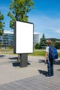 Mock up. Child looking at blank billboard outdoors, outdoor advertising, public information board in the street.