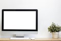 A mock up computer device on a table with white wall.