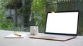 Mock up computer laptop with blank screen on wooden table at comfortable workplace Royalty Free Stock Photo