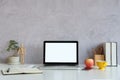 Mock up computer laptop, books, coffee cup and houseplant on white desk with cement wall Royalty Free Stock Photo