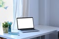 Computer laptop, books and houseplant on white table in comfortable living room. Royalty Free Stock Photo