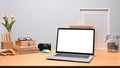 Computer laptop, books and pencil holder on wooden desk. Royalty Free Stock Photo