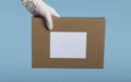 Mock up cortona box with itikotka in curer`s hand isolated on blue background. Gift parcel delivery concept close up Royalty Free Stock Photo