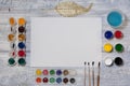 Mock up. Creative space. Artist workspace on vintage wooden table: watercolor, white paper, paint brushes, gouache paints, water a