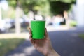 Mock up of cup coffee in woman`s hand bright background for break, energy and strength, hot drink in paper cup