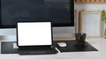 Digital tablet with empty screen, computer and coffee cup on white office desk. Royalty Free Stock Photo