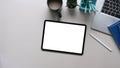 Digital tablet with empty screen, laptop, stationery and coffee cup on white table. Top view. Royalty Free Stock Photo