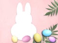Mock up Easter composition with bunny template frame, multicolor eggs, palm leaves on pink background Royalty Free Stock Photo