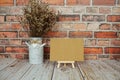 Mock up empty blank paper card on wooden easel with dried flowers bouquet Royalty Free Stock Photo