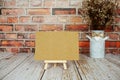 Mock up empty blank paper card on wooden easel with dried flowers bouquet Royalty Free Stock Photo