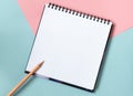 Mock up of empty spiral sketchbook with white paper on pastel pink and blue background. Top view of open notebook with Royalty Free Stock Photo