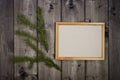 Mock up empty wood frame and fir sprig on dark pine wood wall background, show text or product. Christmas theme Royalty Free Stock Photo