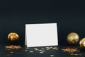 Mock up greeting card on dark background with Christmas decorations glitter snowflakes, baubles, bell and stars confetti. Invitati