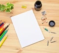 Mock up greeting card on the wooden background next to the pencils and pencil sharpeners, ink for drawing and calligraphy pens Royalty Free Stock Photo