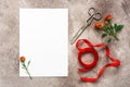 Mock up greeting or invitation card. Blank paper card, red silk ribbon, roses and vintage scissors. Grunge background. Top view,