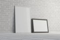 Mock up of horizontal and vertical black and white frames on the floor with white brick wall Royalty Free Stock Photo