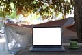 Laptop computer with blank screen on folding picnic table near camp tent outdoors. Royalty Free Stock Photo