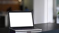 Laptop computer with blank white screen on black wooden table at modern office. Royalty Free Stock Photo