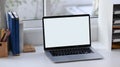 Laptop computer with empty screen, books and office supplies on white office desk. Royalty Free Stock Photo