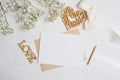 Mock up letter with a love box in the shape of a heart lies on a wooden white table with gypsophila flowers, a greeting Royalty Free Stock Photo