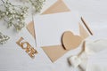 Mock up letter with a love box in the shape of a heart lies on a wooden white table with gypsophila flowers, a greeting Royalty Free Stock Photo