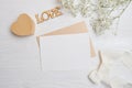 Mock up letter with a love box in the shape of a heart lies on a wooden white table with gypsophila flowers, a greeting Royalty Free Stock Photo