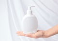 Mock up liquid gel soap. Female hand holding bottle with dispenser Royalty Free Stock Photo