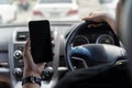 Mock up of man using mobile smart phone inside a car. Driver hand holding blank black screen smartphone, searching address Royalty Free Stock Photo