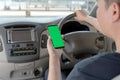 Mock up of man using mobile smart phone inside a car. Driver hand holding blank green screen smartphone, searching address and pin Royalty Free Stock Photo