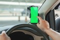 Mock up of man using mobile smart phone inside a car. Driver hand holding blank green screen smartphone, searching address and pin Royalty Free Stock Photo