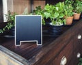 Mock up Menu Chalkboard stand with organic herb plants display on Wooden table