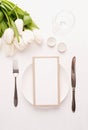 Mock up menu frame in restaurant or cafe. Top view of table setting with menu card, cutlery, fresh white tulips, wine glass and Royalty Free Stock Photo