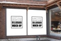 Mock up outdoor billboard on the wall near glass windows Royalty Free Stock Photo