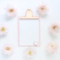 mock up pink clipboard and gently pink chrysanthemum flowers on a white background. Space for text Royalty Free Stock Photo