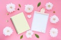 Mock up pink clipboard, yellow notepad on a spring heart and pink flowers on a pink background.